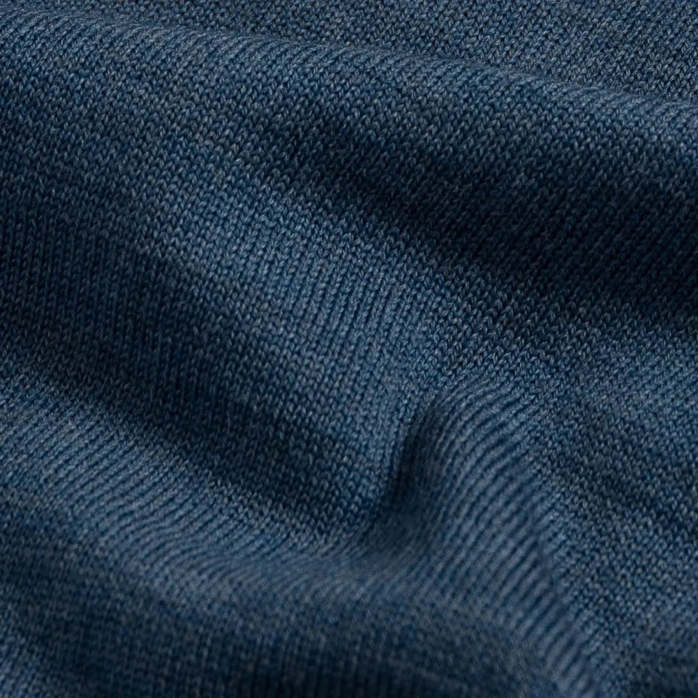 A close-up of a dark blue ribbed knit fabric texture with soft folds.