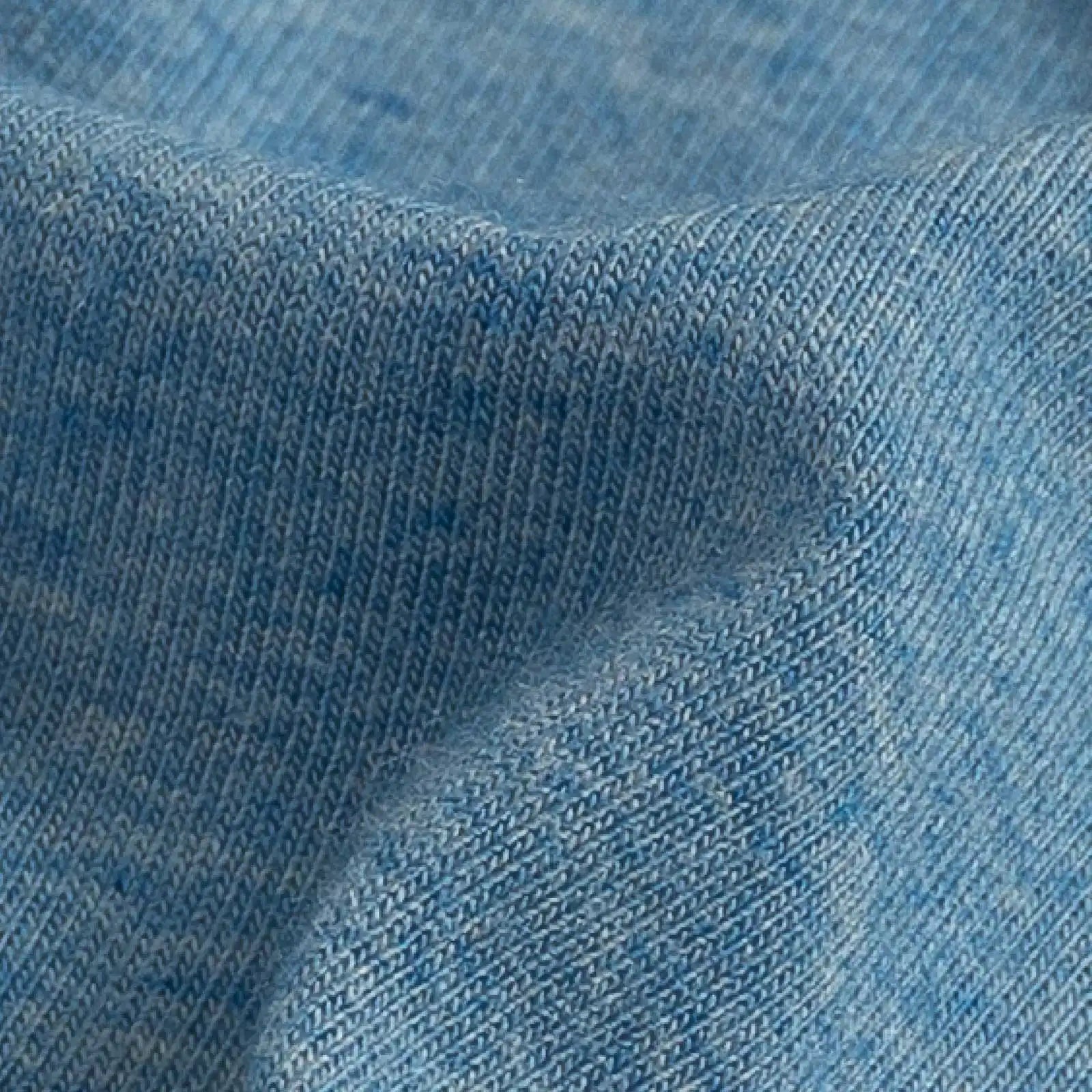 A close-up of light blue knit fabric with a fine ribbed texture and soft folds.