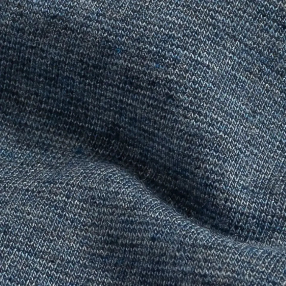 A close-up of a heathered blue knit fabric texture with a fine ribbed pattern and soft folds.