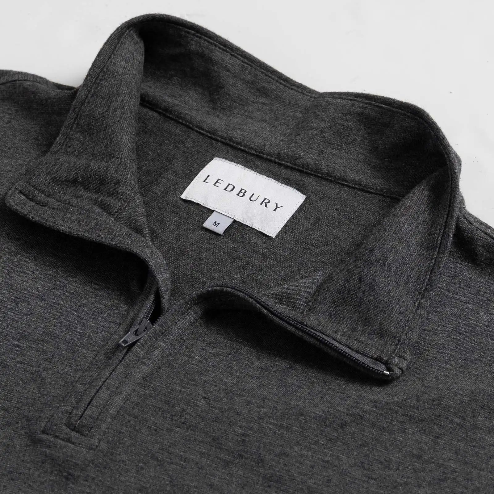 Close-up of quarter-zip collar and Ledbury label on Freeman Sport Quarter Zip in Charcoal Grey