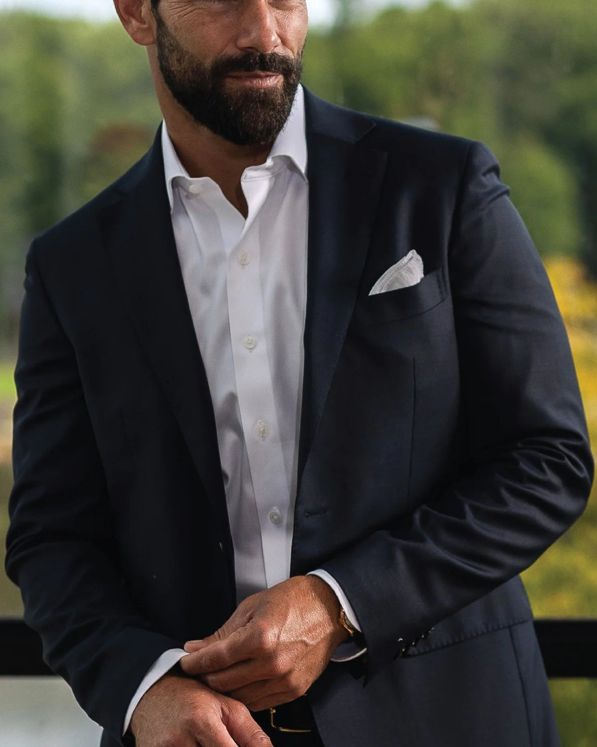 Man wearing a white non iron dress shirt by Ledbury with a navy suit jacket on top.
