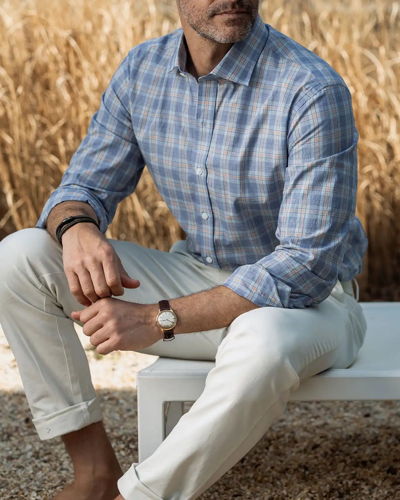 Man wearing the Ledbury Khal blue, green and light orange check dress shirt and light khakis in an outdoor setting