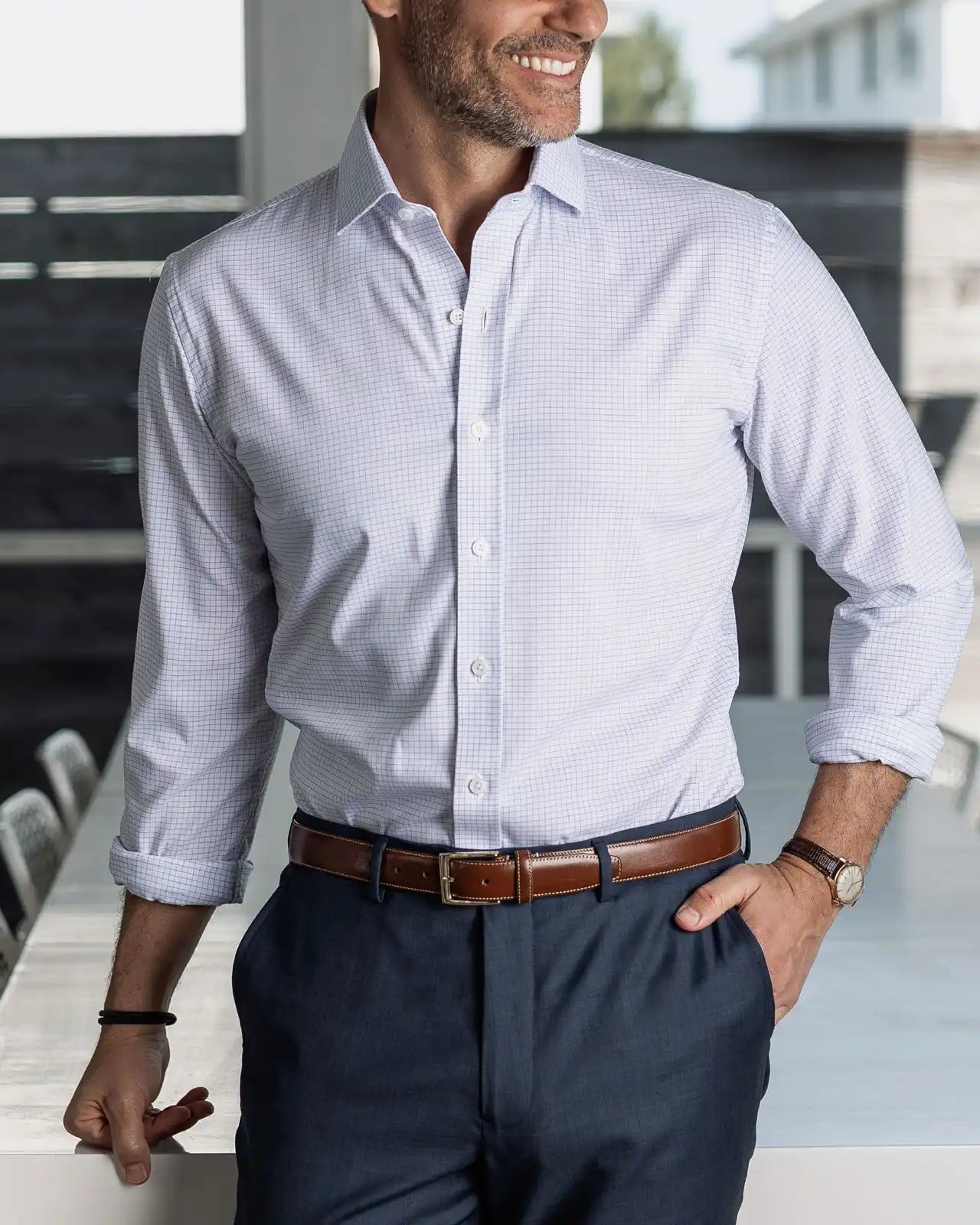 Man wearing a navy micro check performance dress shirt and navy chinos in an indoor setting