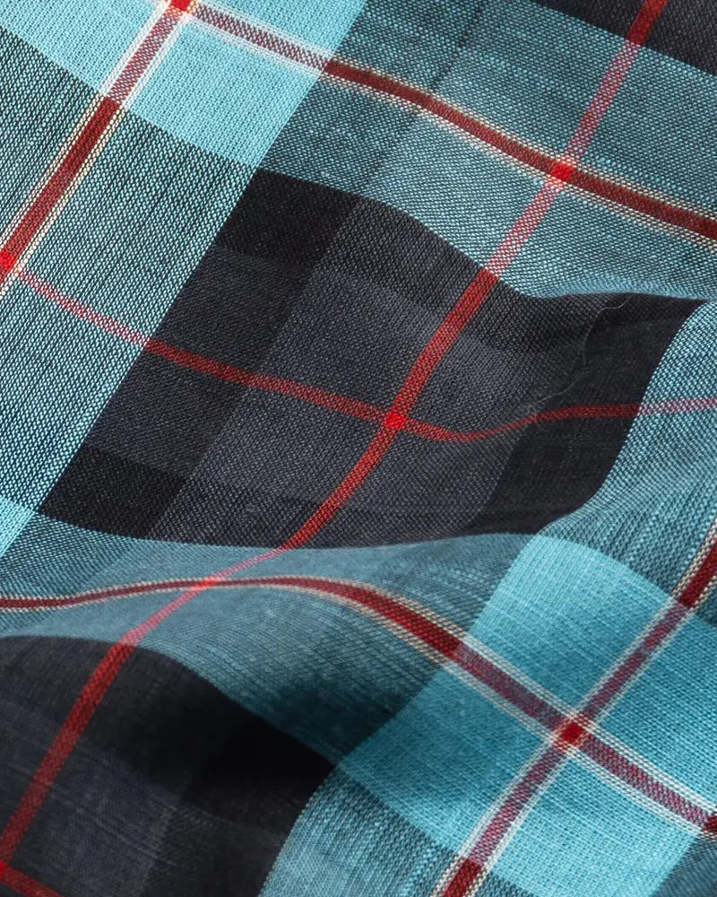 Close-up of Ledbury Blue Albini Olson Plaid 100% cotton chambray fabric texture, teal navy and red plaid weave