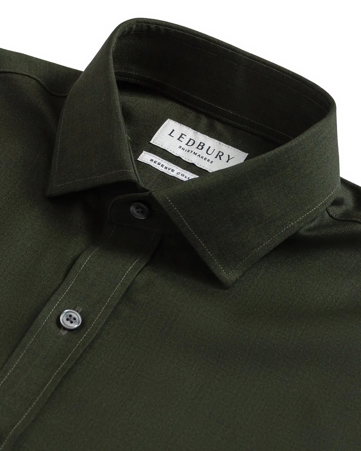 Close-up of a dark olive green LEDBURY long-sleeve shirt, showing the collar, button-down front, and LEDBURY brand label.