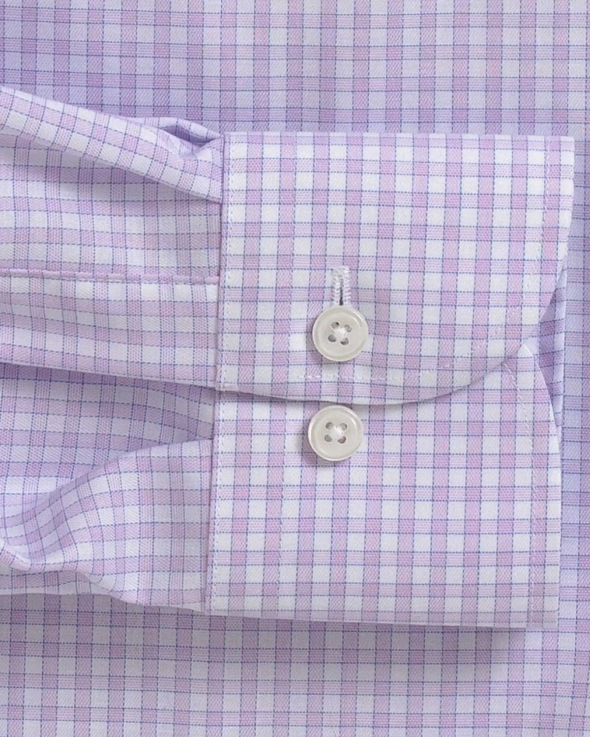 Close-up of a lavender and white gingham checkered dress shirt cuff with two white buttons.