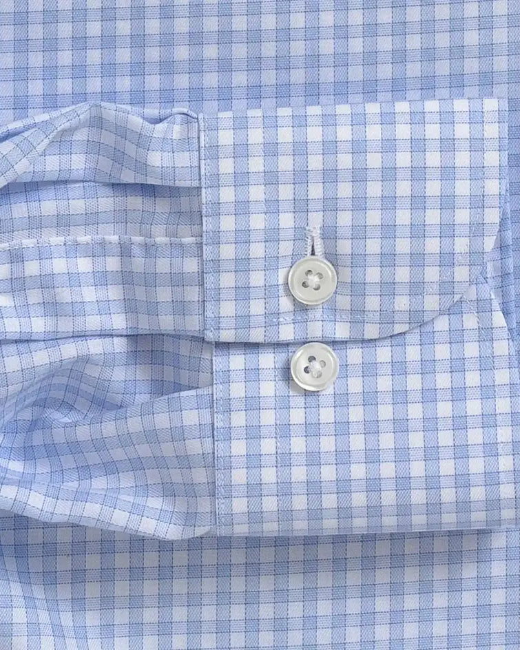 Close-up of a light blue and white gingham checkered shirt cuff with white buttons.