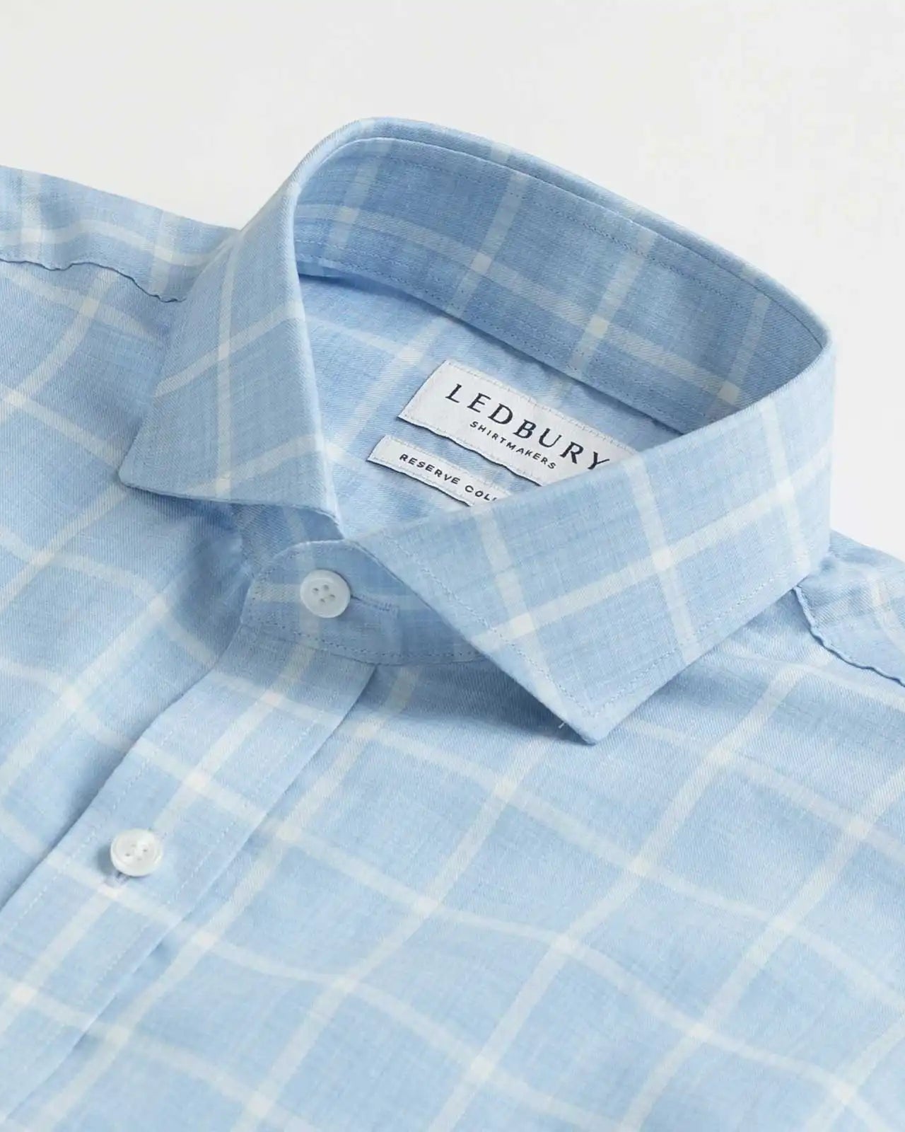 Collar detail of an Italian Albini light blue and white checkered button down shirt