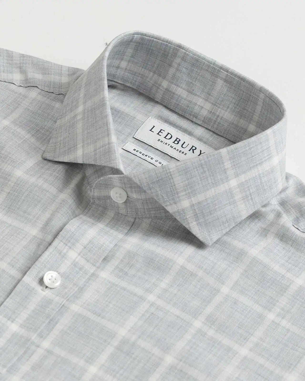 Collar detail of an Italian Albini light grey and white checkered button down shirt