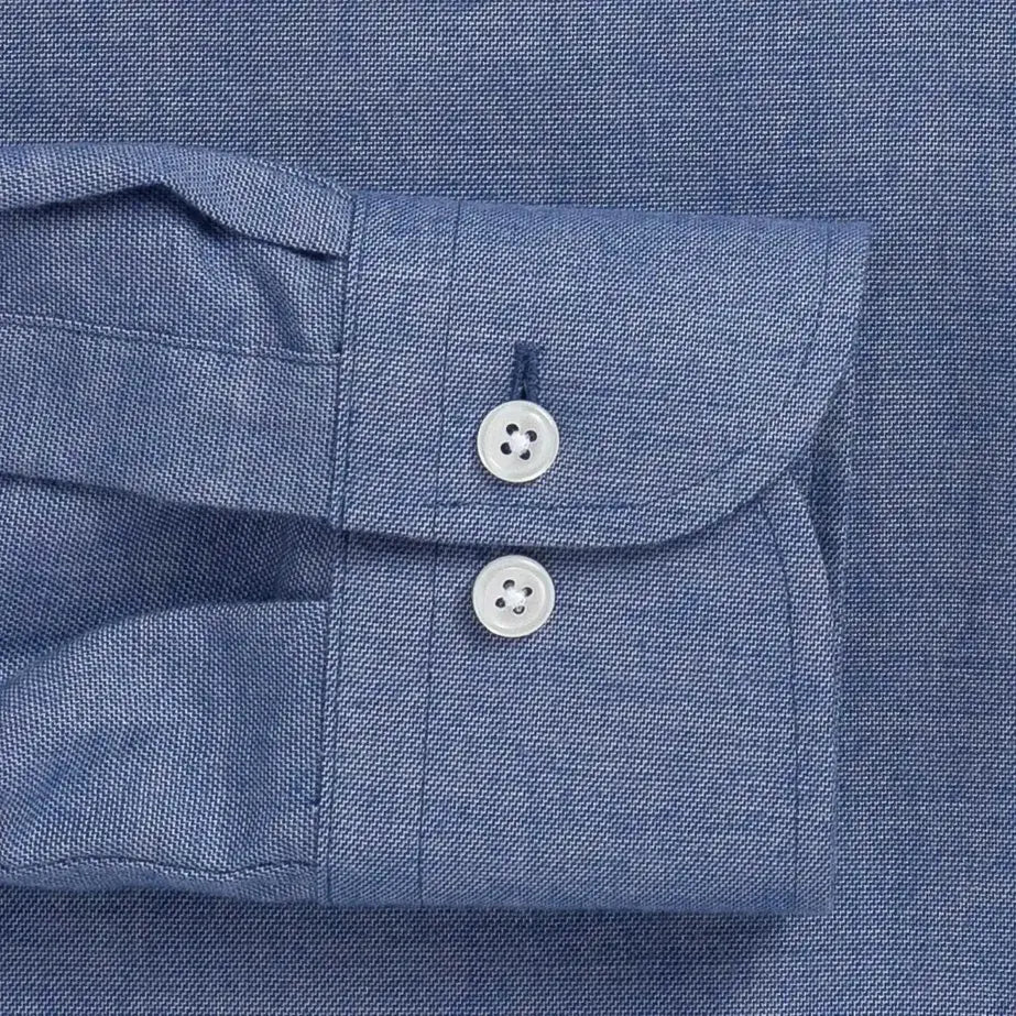 Close-up of a blue brushed oxford button down shirt sleeve