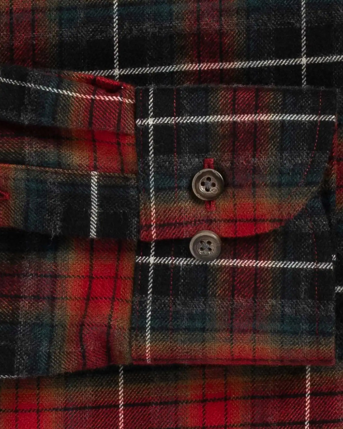 Close-up of a red and black plaid flannel shirt cuff with two buttons and white stripe lines.