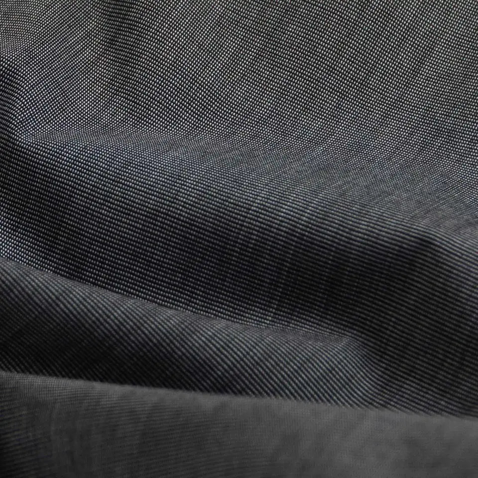 A close-up of dark charcoal gray fabric with a fine diagonal twill weave and soft folds.