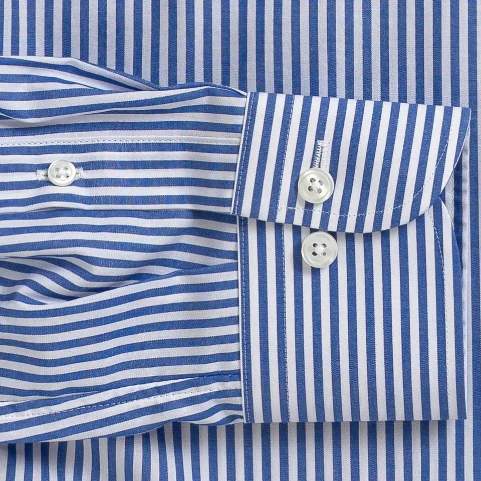 Close-up of a blue and white striped long-sleeve dress shirt cuff with two white buttons, laid flat against the matching striped fabric.