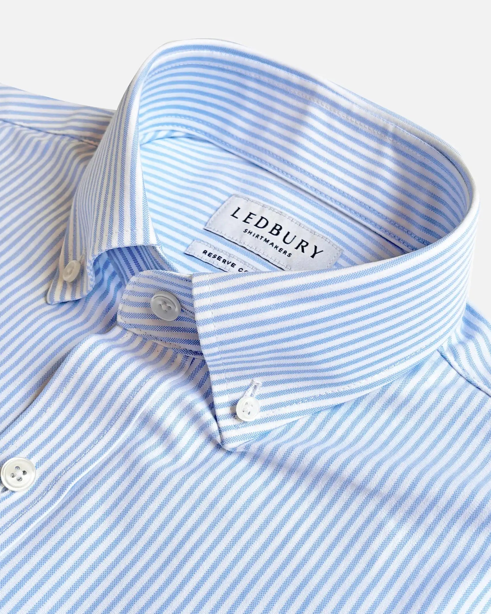 Close-up of a light blue and white striped button-down shirt collar with the LEDBURY brand label visible inside the neck.
