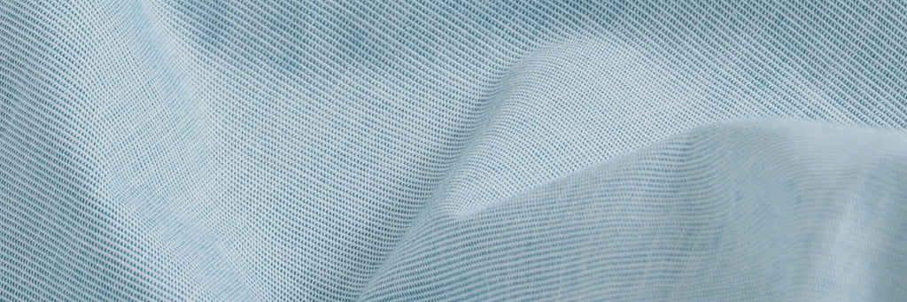 Closeup of the fabric of a men's light mint green button down dress shirt 