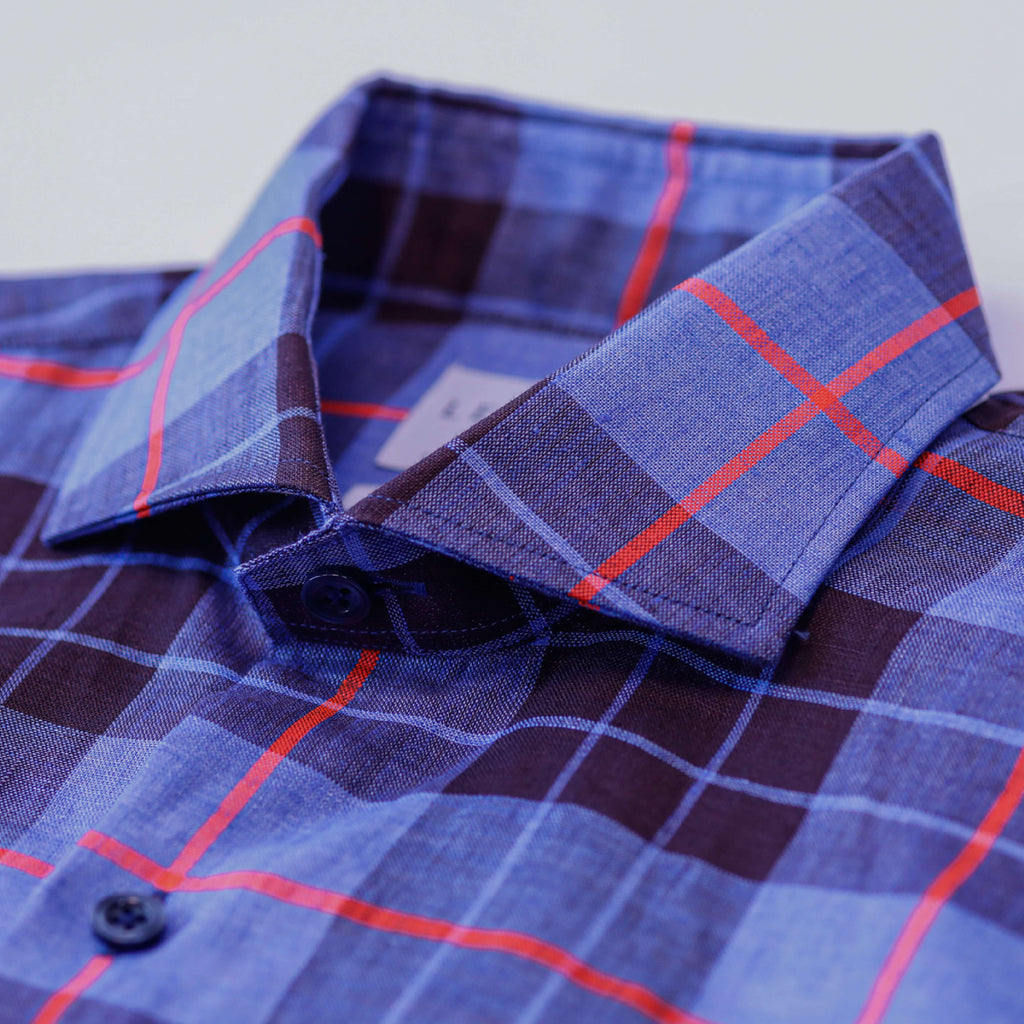 Closeup of the collar of a men's royal blue, black and red bold summer weight plaid button down shirt 