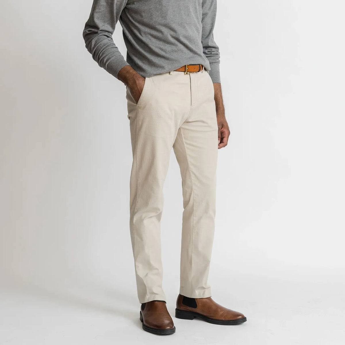 Model wearing tan richmond chinos and a lightweight grey sweater