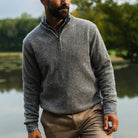 Man standing in an outdoor setting wearing a heathered grey half zip merino wool and cashmere sweater by Ledbury