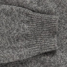 Close-up of a heather gray knit fabric with a ribbed cuff detail.