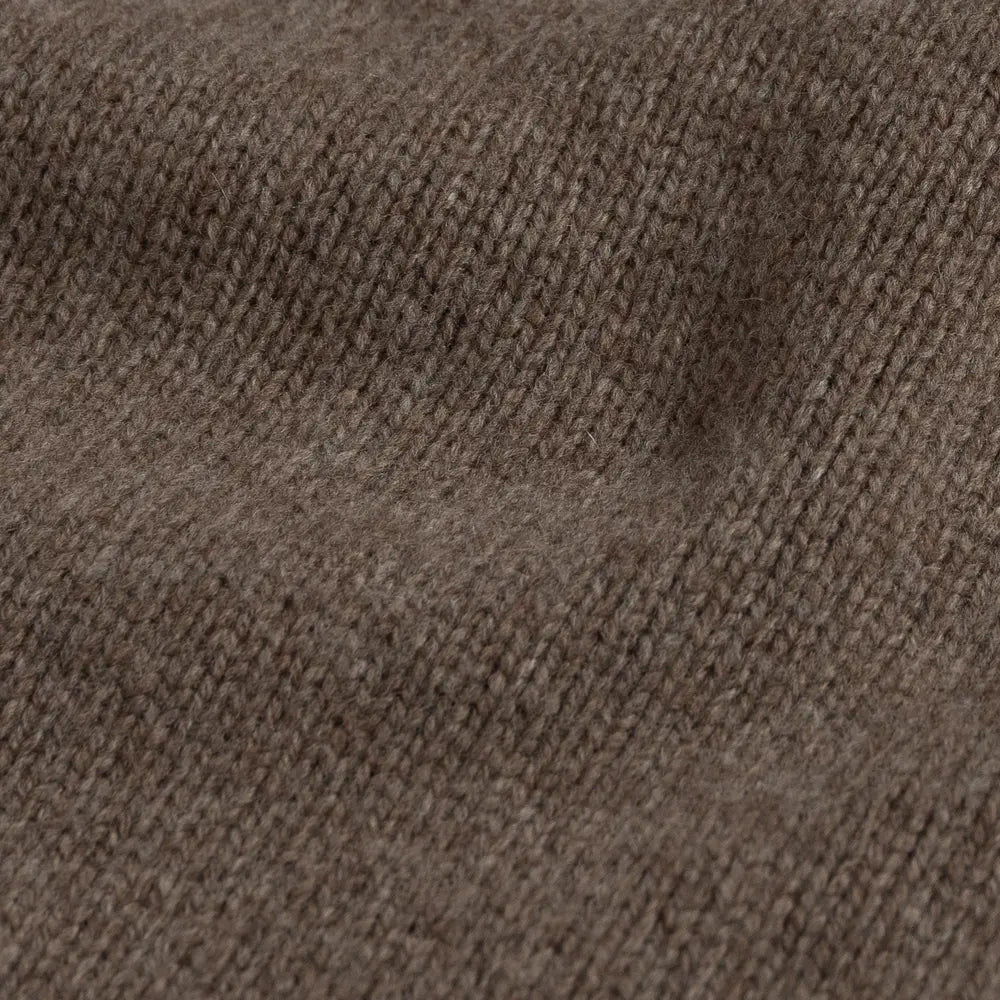Close-up of a brown 100% Italian merino wool knit sweater fabric with a fine ribbed pattern.