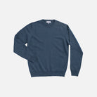 A slate blue crewneck sweater laid flat against a light gray background.