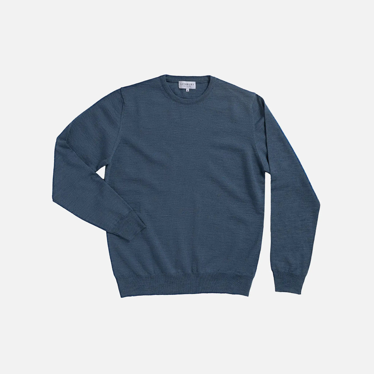 A slate blue crewneck sweater laid flat against a light gray background.