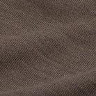 A close-up of a textured knit fabric in a dark taupe-brown color, showing the detailed weave and soft folds.