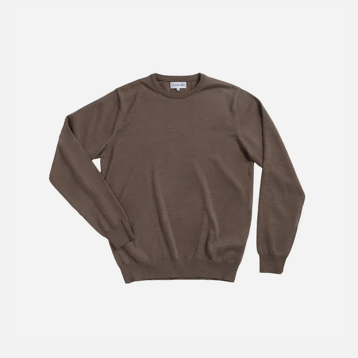A brown long-sleeve crewneck sweater laid flat against a light gray background.