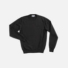A dark charcoal gray crewneck sweater with long sleeves, laid flat against a light gray background.