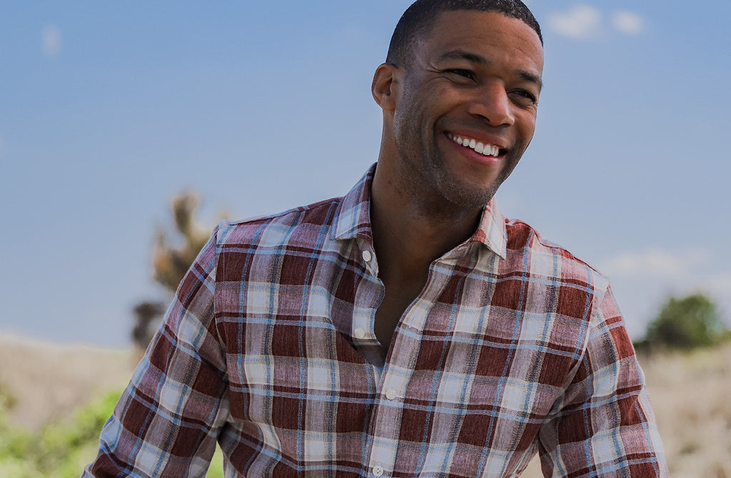 Model wearing a brick red, blue and white men's button down shirt