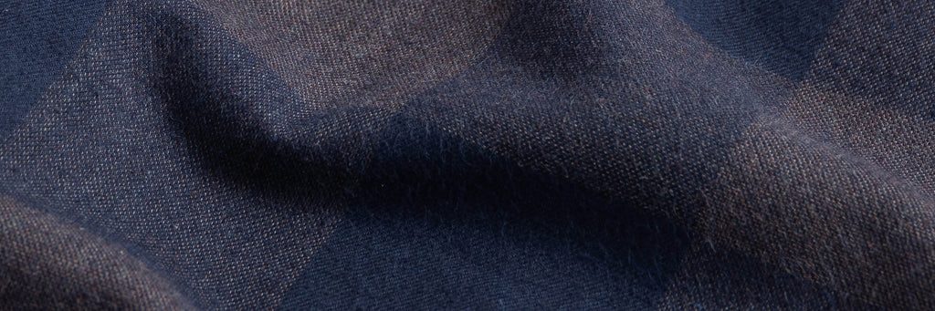 Closeup of the fabric of a men's navy and grey checked flannel shirt