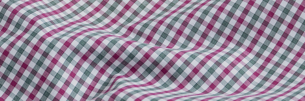 Closeup of the fabric of a berry red and dark green checked men's dress shirt