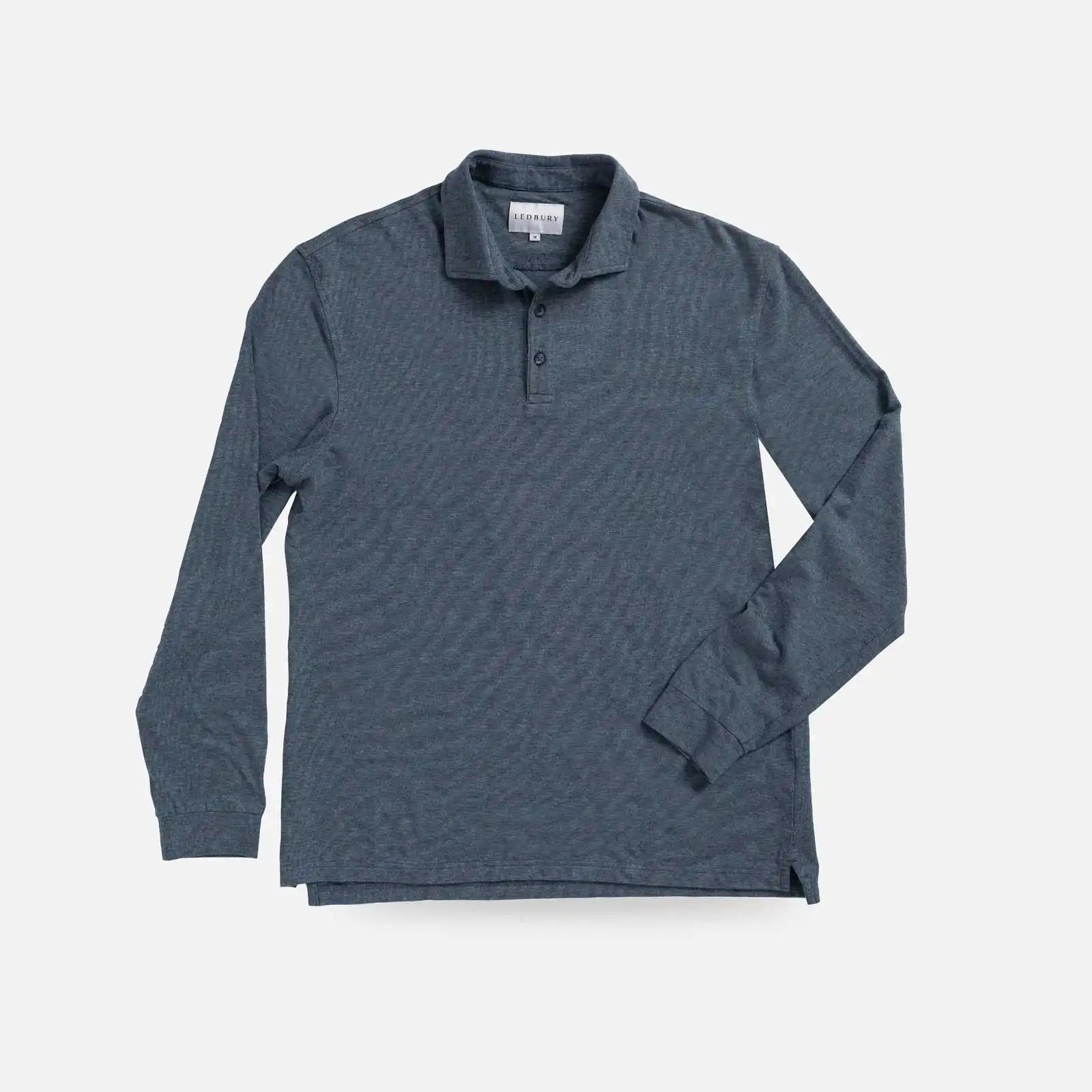 A dark slate blue long-sleeve polo shirt with a subtle textured pattern, laid flat against a light gray background.