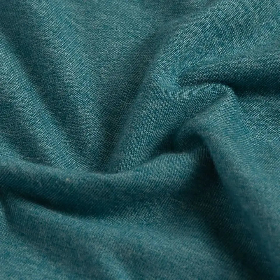 A close-up of draped teal blue fabric with a soft, slightly heathered texture.