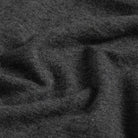 A close-up of dark charcoal gray knit fabric with soft folds and a fine ribbed texture.
