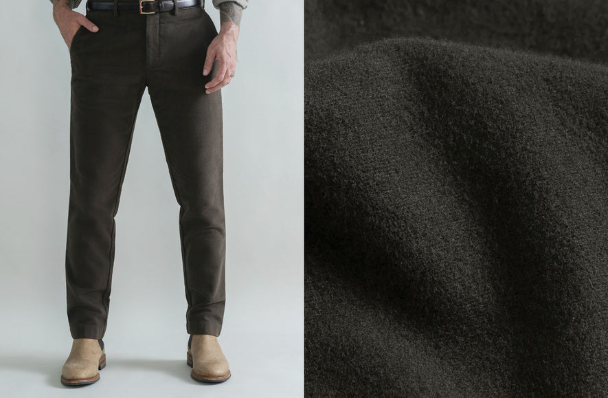 A split image showing a man wearing dark charcoal gray slim-fit trousers from the waist down, paired with tan boots, alongside a close-up texture shot of the dark charcoal wool fabric.