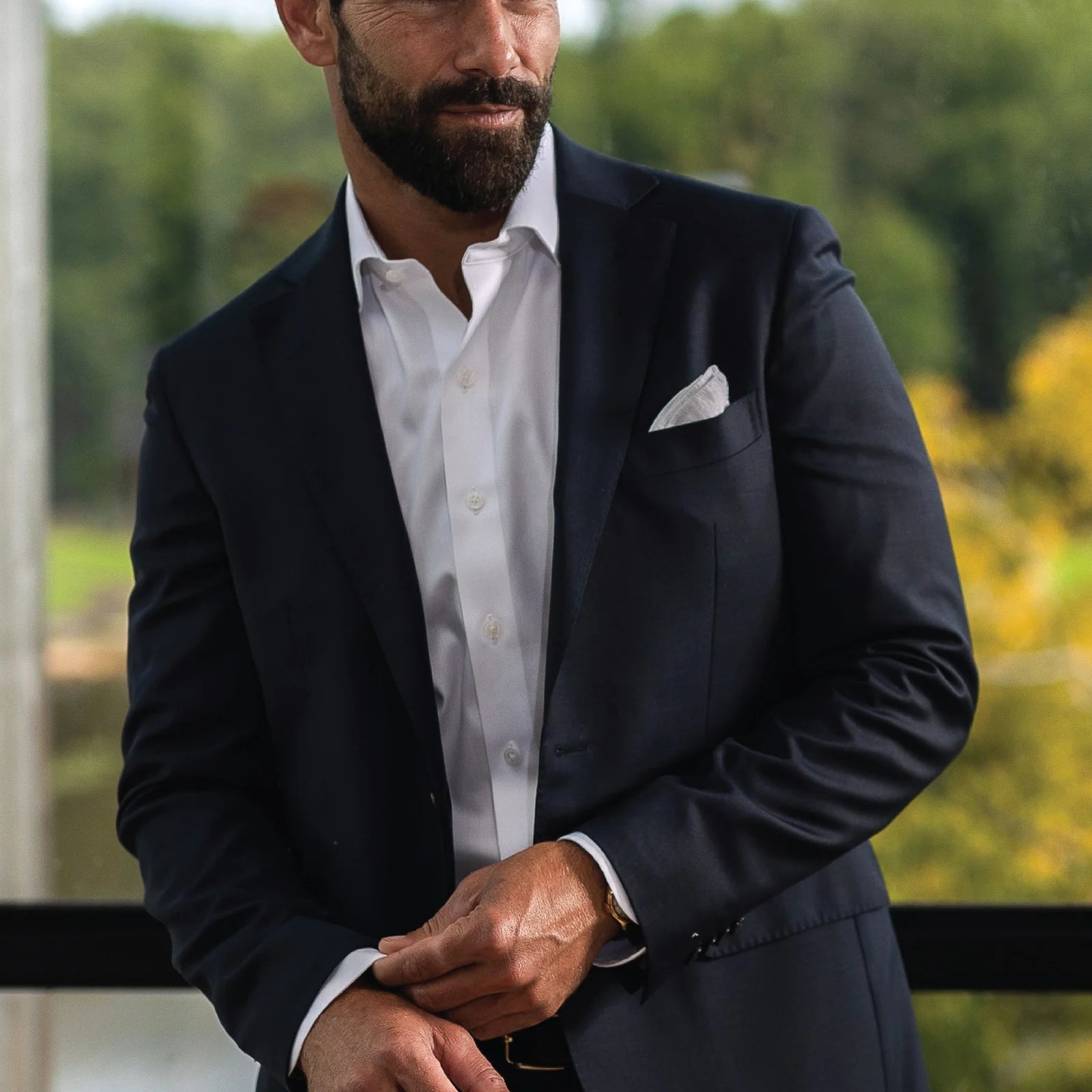 Man wearing a white non iron dress shirt by Ledbury with a navy suit jacket on top. 