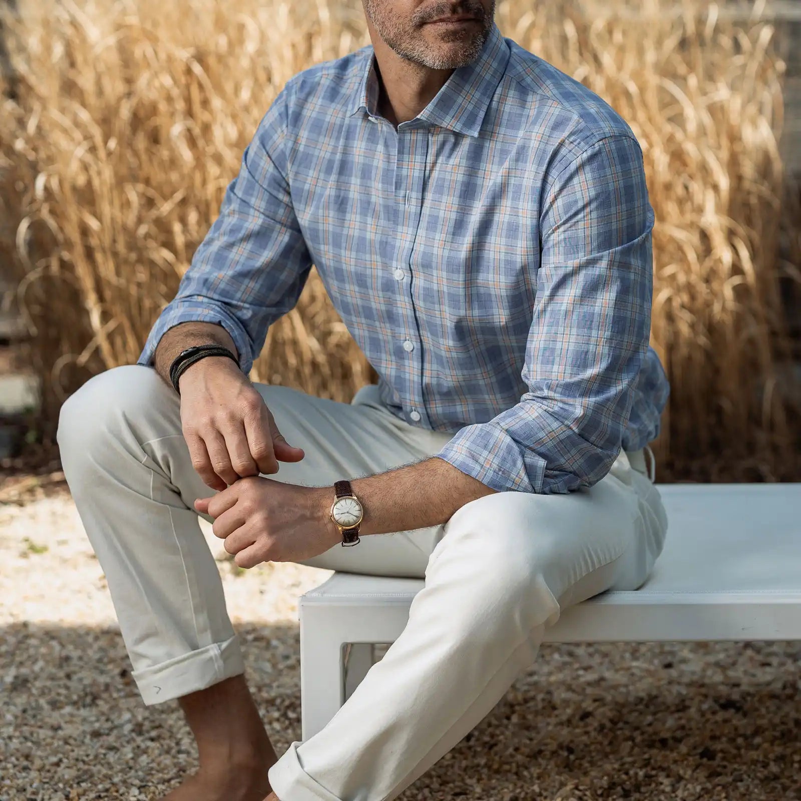 Man wearing the Ledbury Khal blue, green and light orange check dress shirt and light khakis in an outdoor setting
