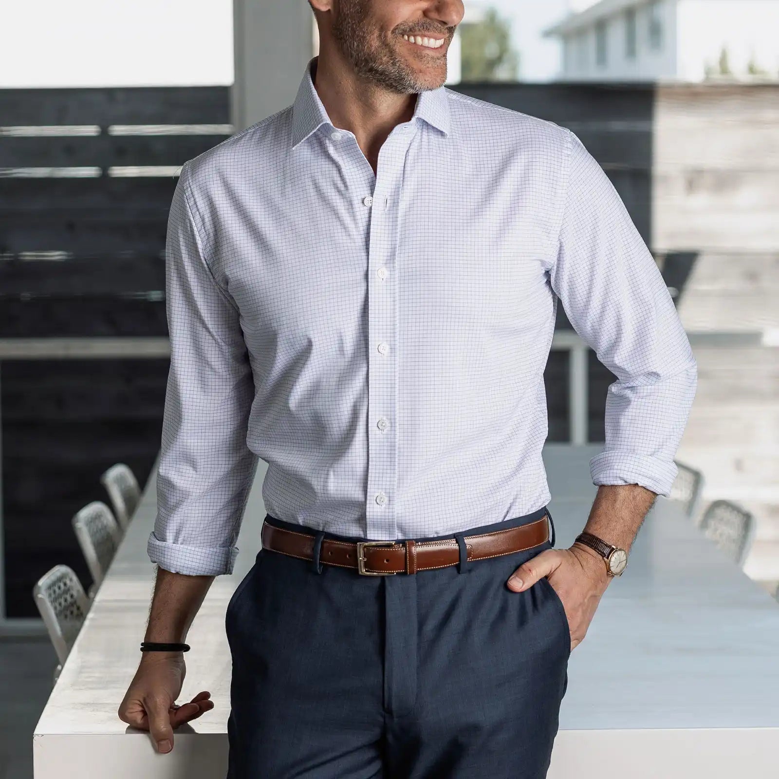 Man wearing a navy micro check performance dress shirt and navy chinos in an indoor setting