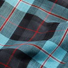 Close-up of Ledbury Blue Albini Olson Plaid 100% cotton chambray fabric texture, teal navy and red plaid weave