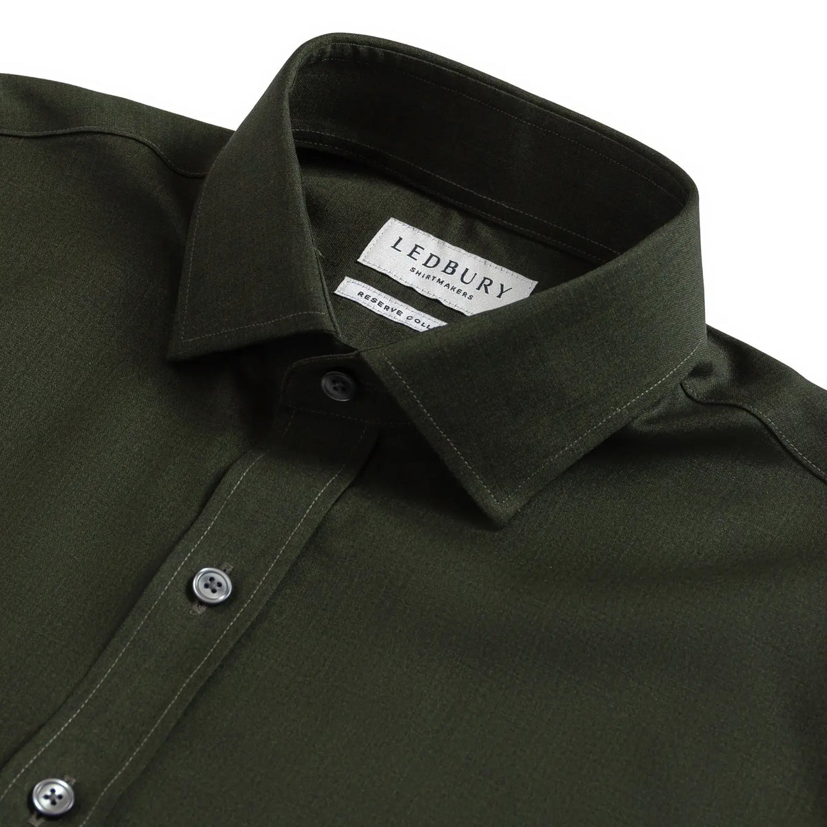 Close-up of a dark olive green LEDBURY long-sleeve shirt, showing the collar, button-down front, and LEDBURY brand label.