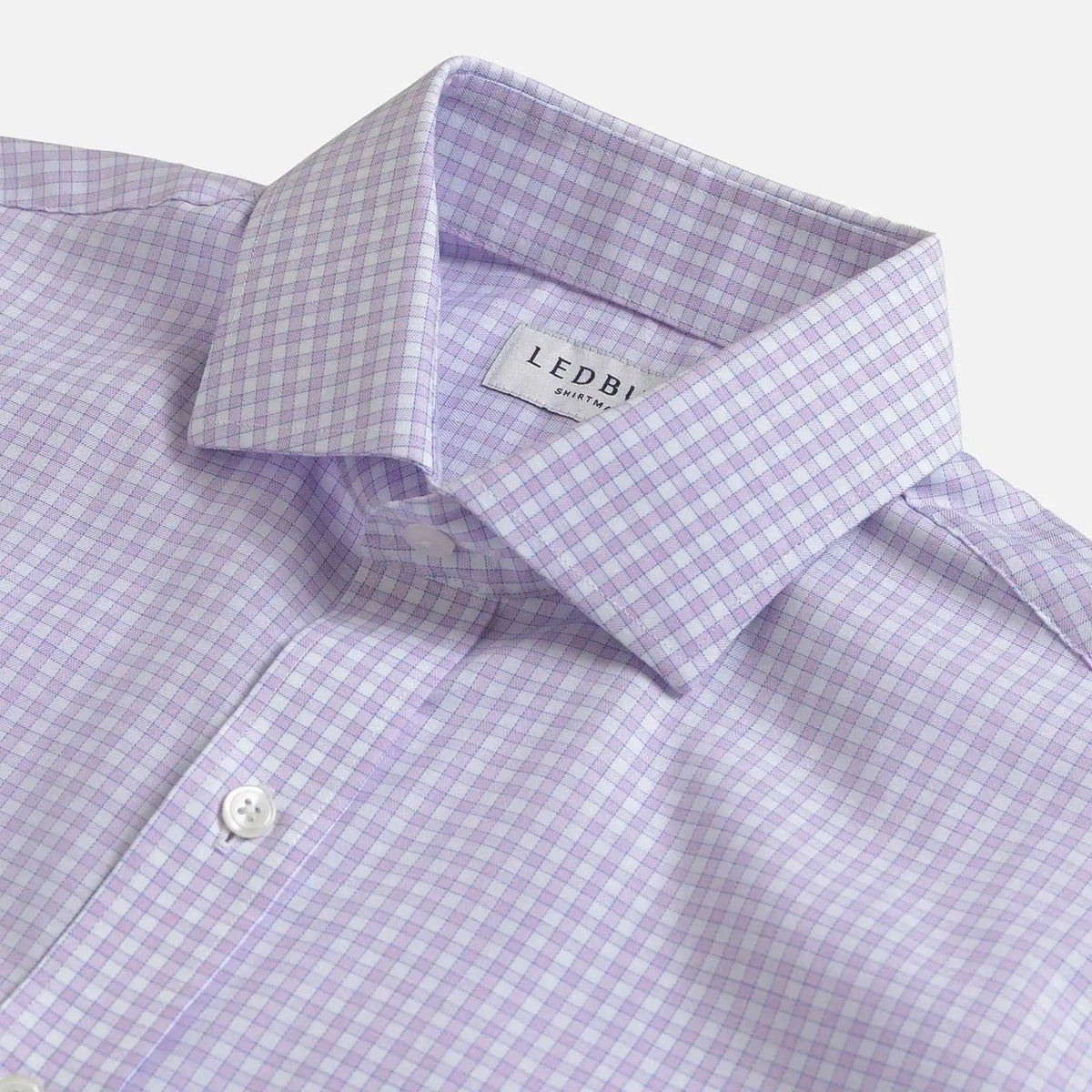 Close-up of a Ledbury men's dress shirt in a light purple and white gingham check pattern, showing the collar and button placket.