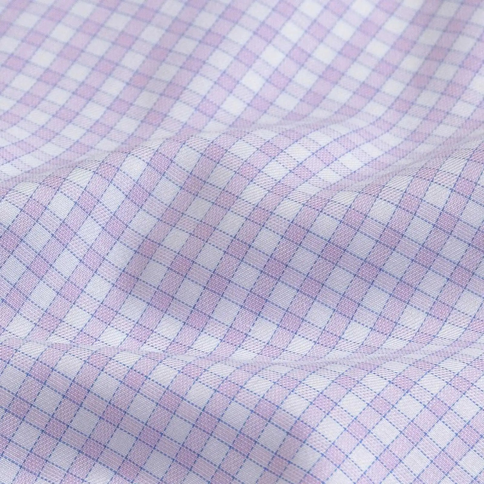 A close-up of a white fabric with a fine lavender and blue gingham check pattern, showing soft folds and texture.
