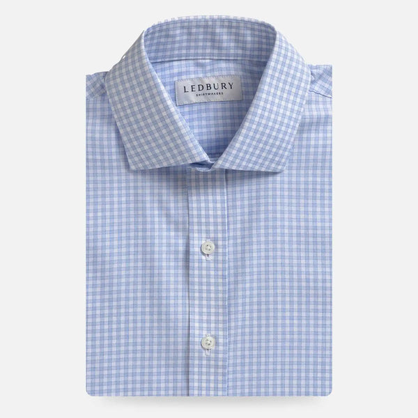 A folded light blue and white gingham dress shirt by Ledbury, featuring a classic collar, white buttons, and a clean white background.