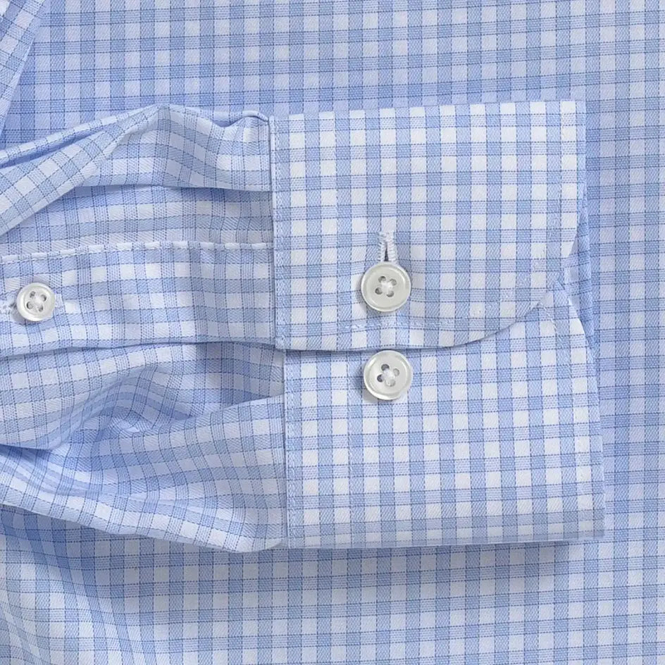 Close-up of a light blue and white gingham checkered shirt cuff with white buttons.