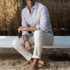Man wearing the Ledbury Peach Santos Check shirt outdoors — peach, blue, and olive cotton seersucker check