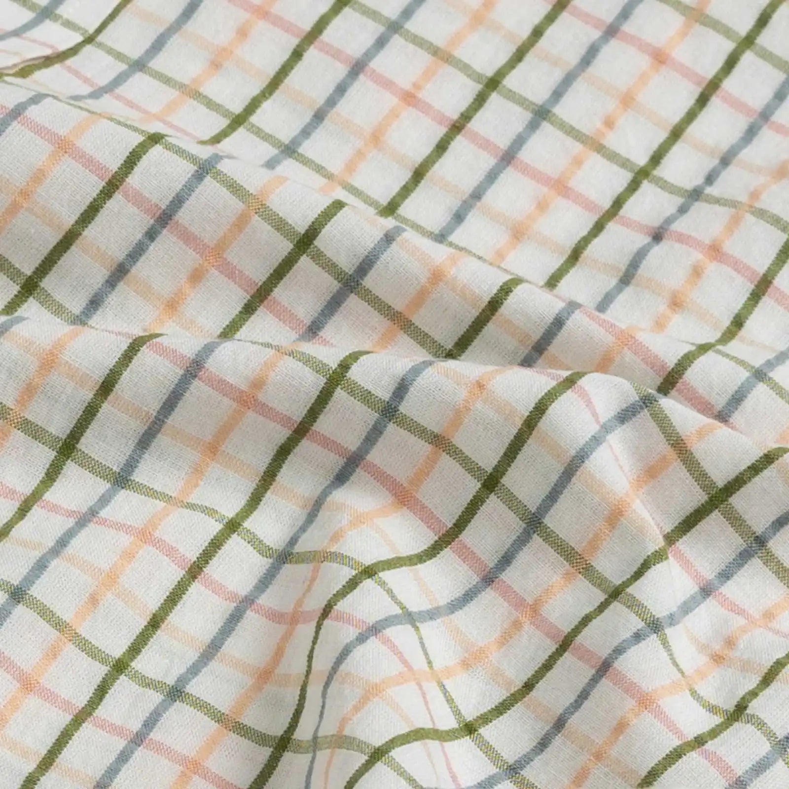 100% cotton seersucker fabric detail of the Peach Santos Check shirt — peach, blue, and olive check