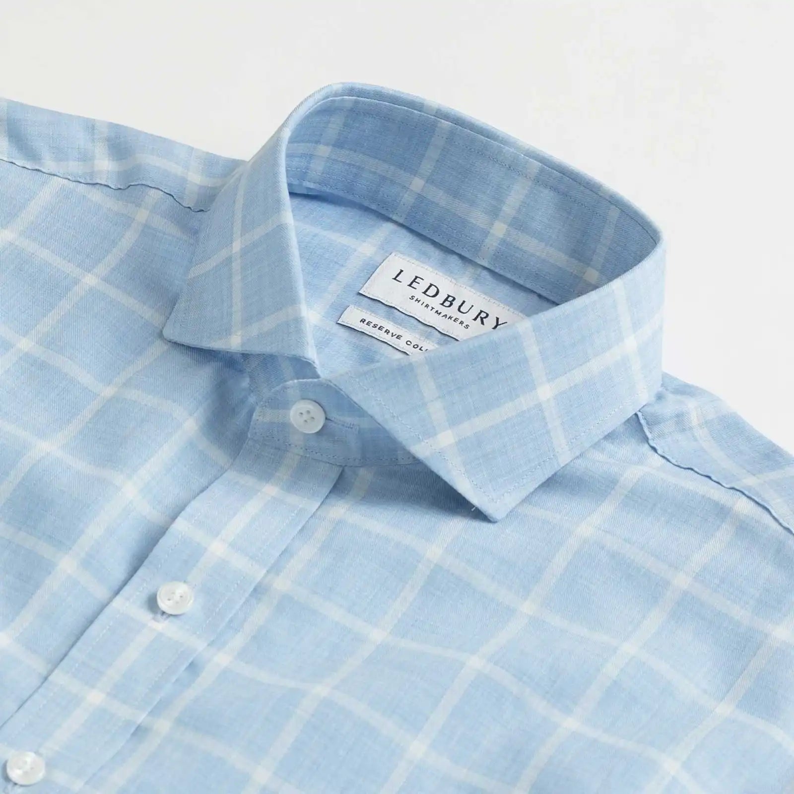 Collar detail of an Italian Albini light blue and white checkered button down shirt
