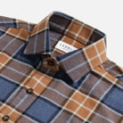 Burnt orange and blue plaid flannel shirt collar and button detail