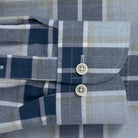 Close-up of the sleeve of a plaid shirt with buttons on a checkered pattern